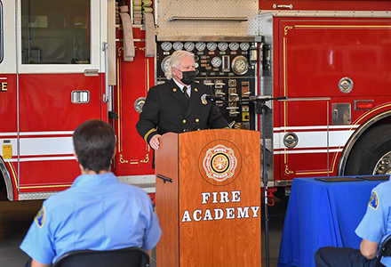 Andy Densmore speaking at a fire academy graduation.